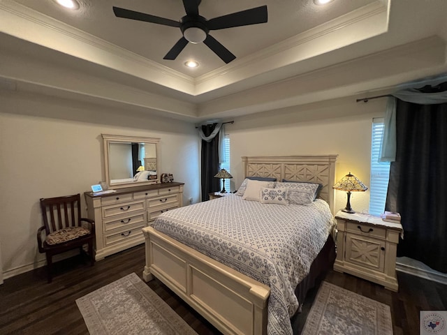 bedroom featuring ceiling fan, a tray ceiling, dark hardwood / wood-style floors, and crown molding