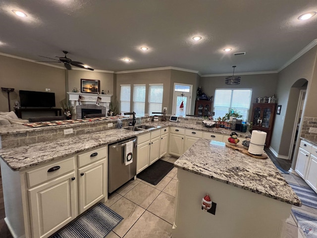 kitchen with dishwasher, sink, a kitchen island, light stone counters, and light tile patterned flooring