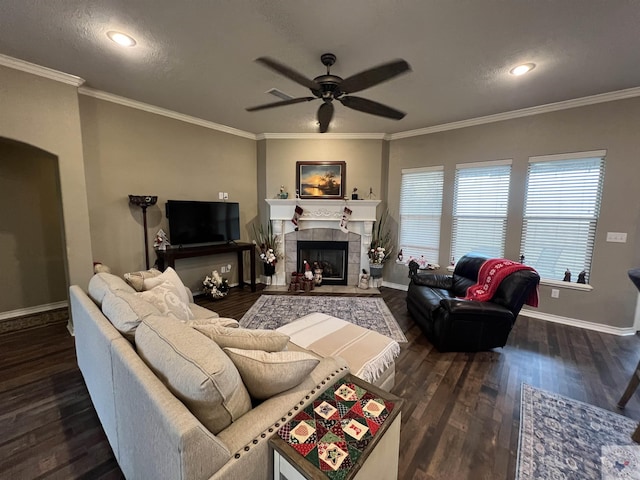 living room featuring ornamental molding, dark hardwood / wood-style flooring, and a tiled fireplace