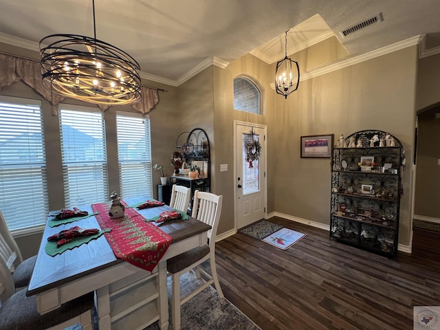 dining area with a chandelier, ornamental molding, and dark wood-type flooring