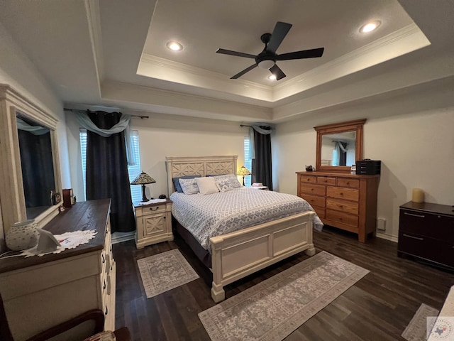 bedroom with ceiling fan, dark wood-type flooring, and a tray ceiling