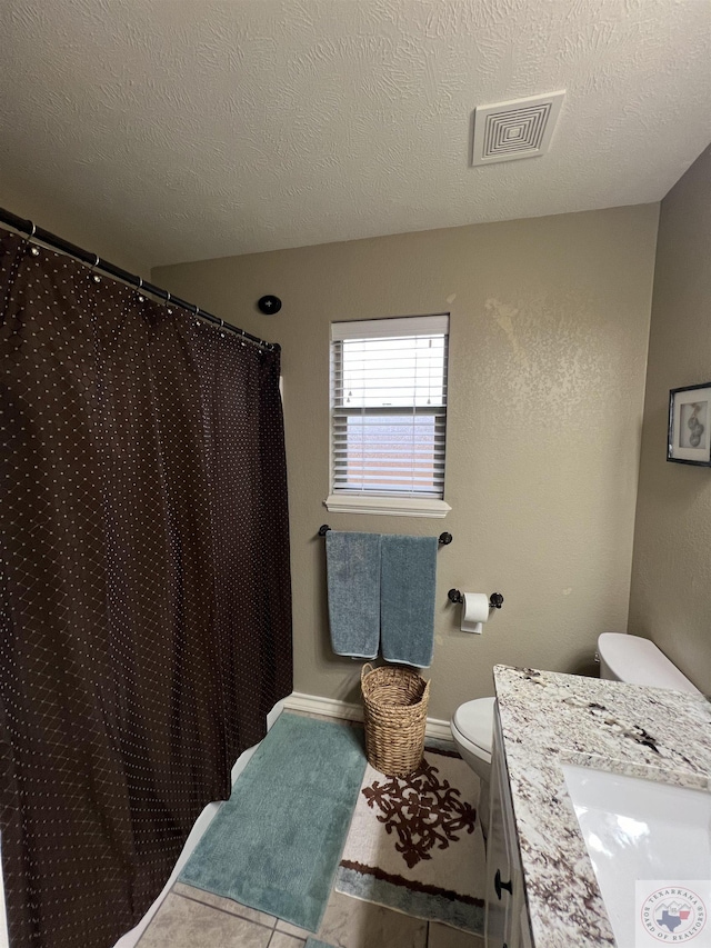 bathroom featuring toilet, a textured ceiling, and vanity