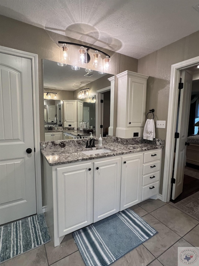 bathroom featuring a textured ceiling, tile patterned floors, and vanity