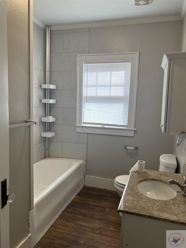 full bathroom with crown molding, vanity, wood-type flooring, shower / bathtub combination, and toilet