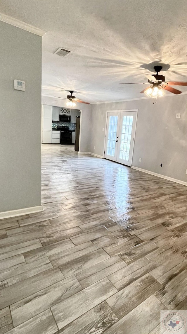 unfurnished living room featuring ceiling fan, light hardwood / wood-style flooring, ornamental molding, and french doors