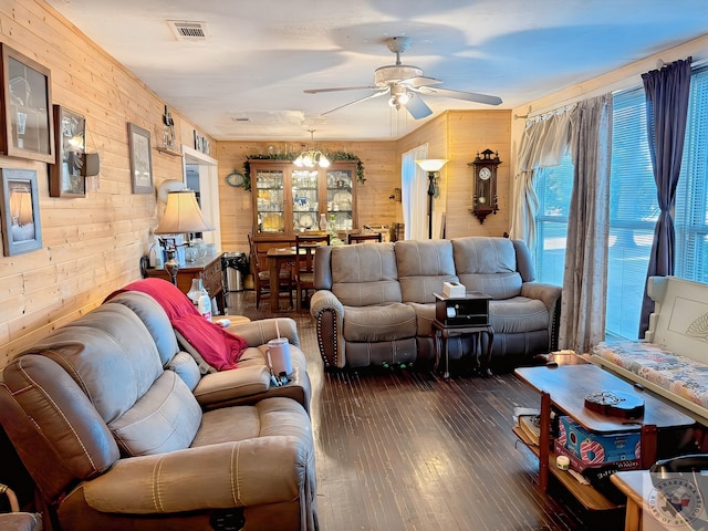 living room featuring ceiling fan, dark hardwood / wood-style flooring, and wood walls