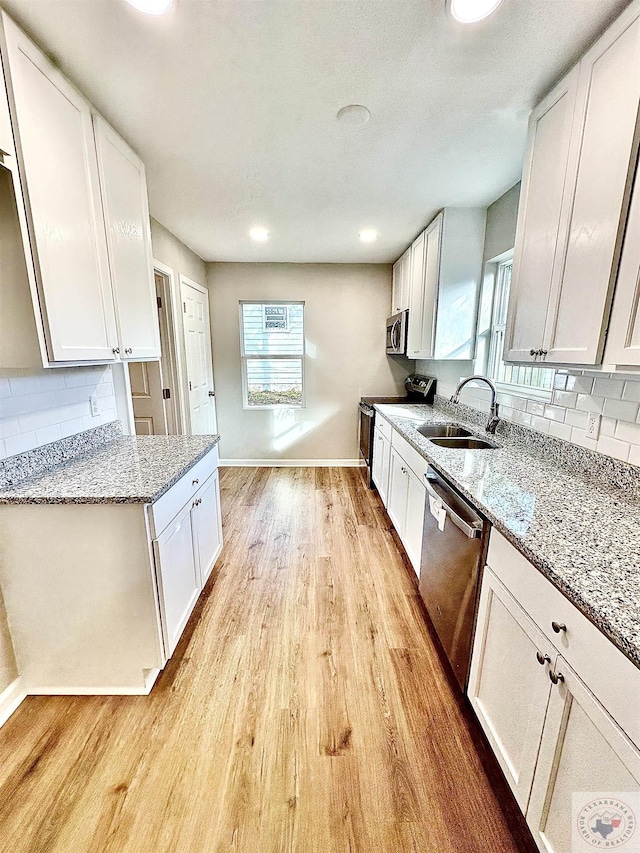 kitchen with sink, decorative backsplash, stainless steel appliances, and white cabinets