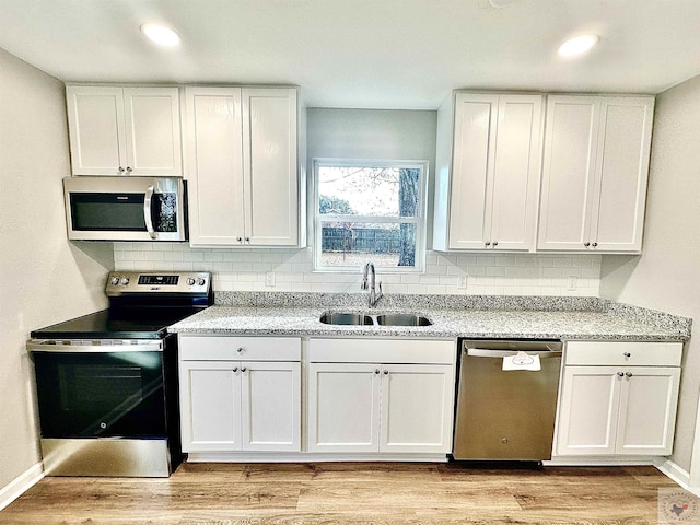 kitchen with stainless steel appliances, sink, and white cabinets