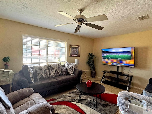 tiled living room with a textured ceiling and ceiling fan