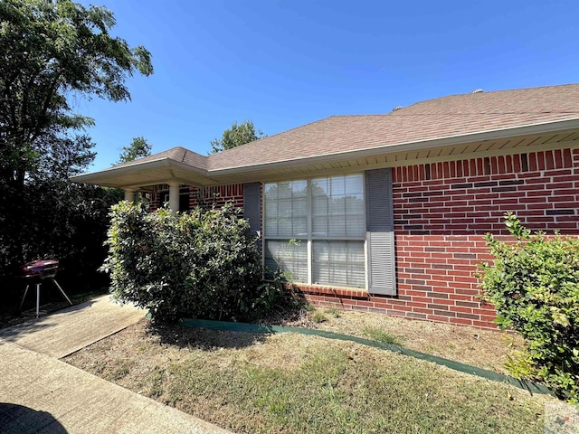 view of side of home with a yard