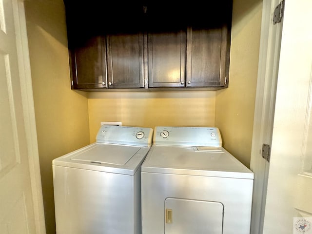 washroom featuring washing machine and dryer and cabinets