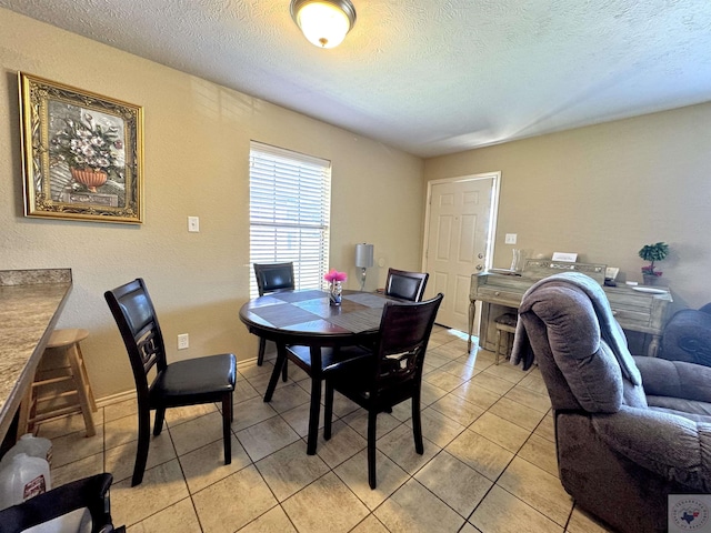 tiled dining room with a textured ceiling