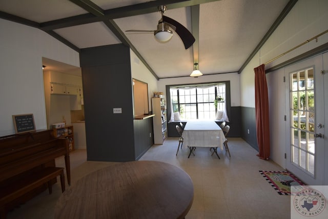 dining area featuring ceiling fan and lofted ceiling with beams