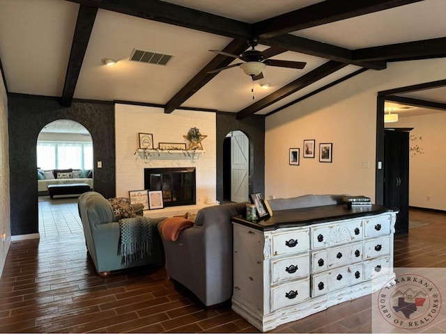 living room with ceiling fan, lofted ceiling with beams, and a brick fireplace