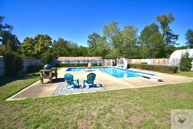 view of pool featuring a diving board, a yard, and a patio