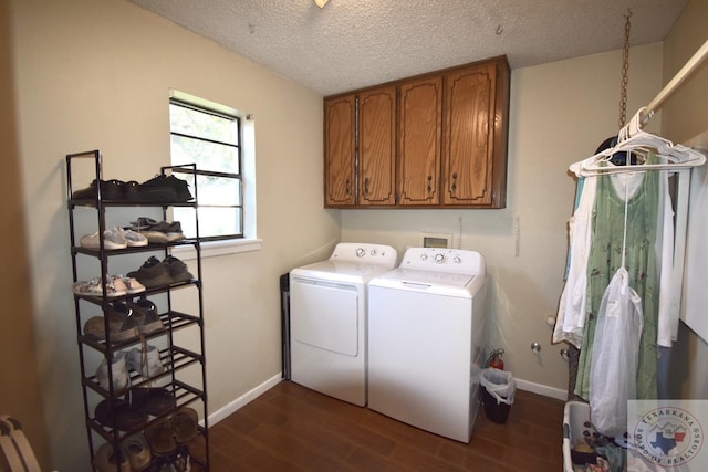 laundry area with dark wood-type flooring, cabinets, a textured ceiling, and washing machine and clothes dryer