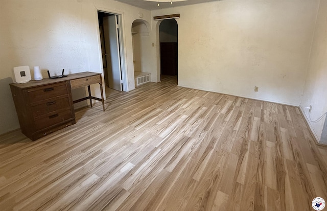 620 E 27th St, Texarkana, AR 71854 - empty room featuring arched walkways and light wood finished floors