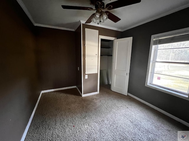 unfurnished bedroom with ceiling fan, a closet, crown molding, and carpet flooring