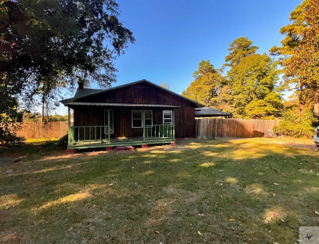 back of property featuring a wooden deck and a lawn