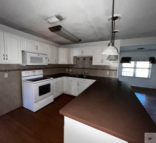 kitchen with hanging light fixtures, sink, white cabinets, white appliances, and dark hardwood / wood-style floors