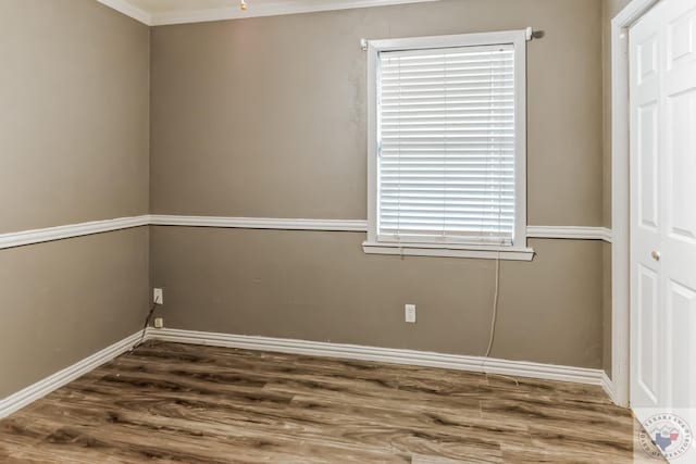 empty room featuring crown molding and dark wood-type flooring