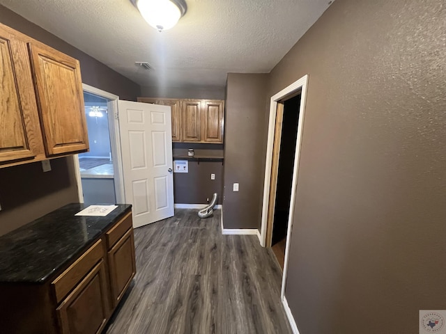 kitchen featuring a textured ceiling and dark hardwood / wood-style flooring