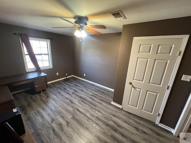 unfurnished bedroom with ceiling fan, dark hardwood / wood-style flooring, and a textured ceiling