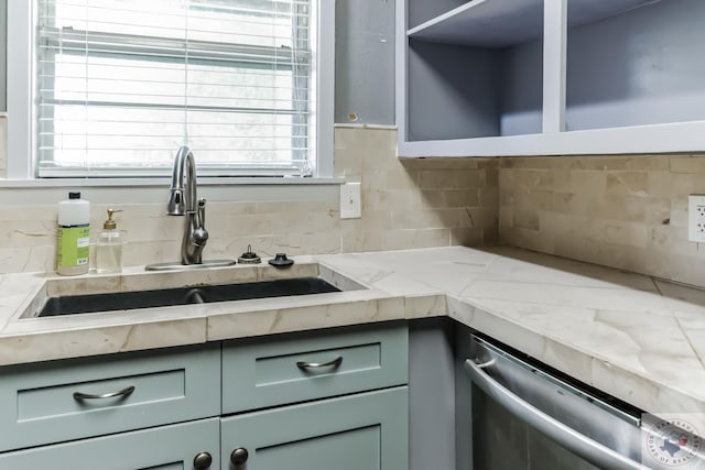 kitchen with dishwasher, sink, backsplash, light stone counters, and green cabinetry