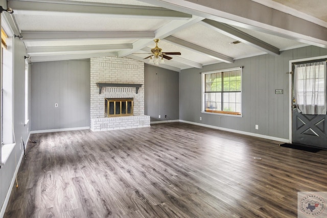 unfurnished living room with vaulted ceiling with beams, a fireplace, dark hardwood / wood-style floors, and ceiling fan