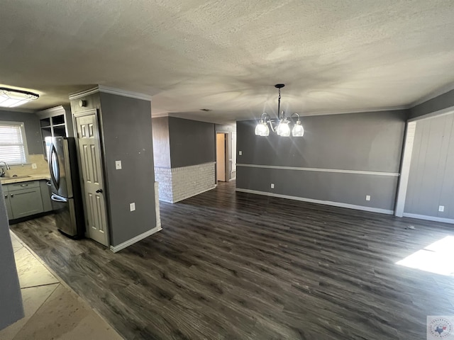 interior space featuring ornamental molding, dark hardwood / wood-style floors, a chandelier, and a textured ceiling