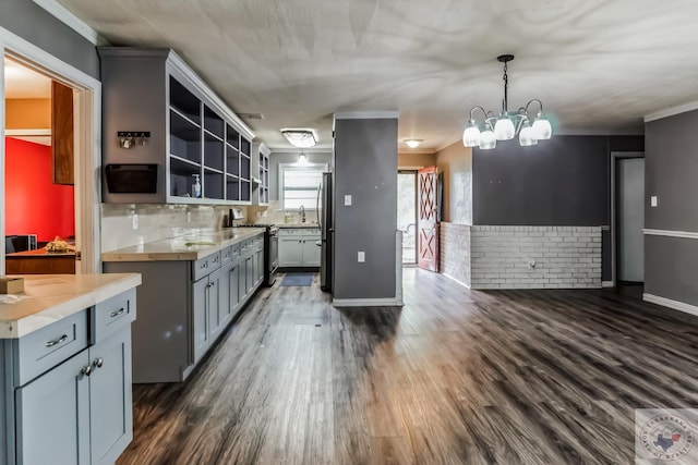 kitchen with ornamental molding, stainless steel appliances, dark hardwood / wood-style flooring, and hanging light fixtures