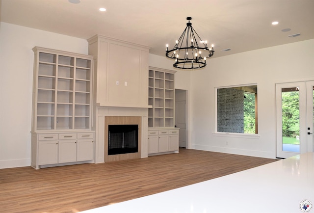 105 Bronco, Texarkana, TX 75503 - unfurnished living room featuring light wood-style flooring, a chandelier, baseboards, recessed lighting, and a fireplace