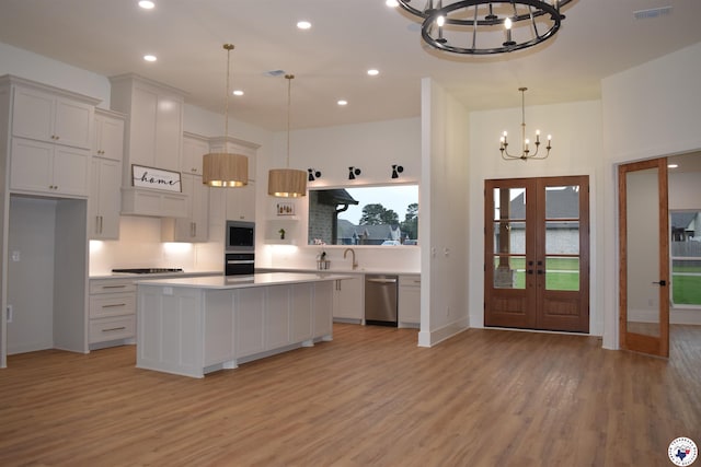105 Bronco, Texarkana, TX 75503 - kitchen featuring a chandelier, appliances with stainless steel finishes, light wood finished floors, light countertops, and french doors