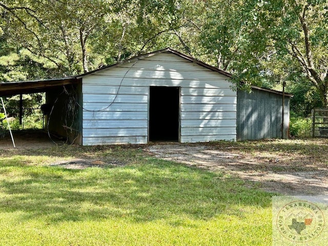 view of outbuilding with a lawn and a carport