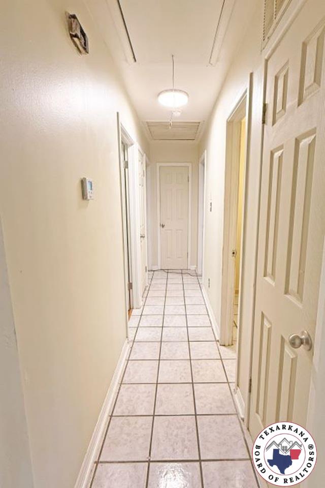 5 Sidney Dr, Texarkana, TX 75503 - hallway with light tile patterned floors and attic access