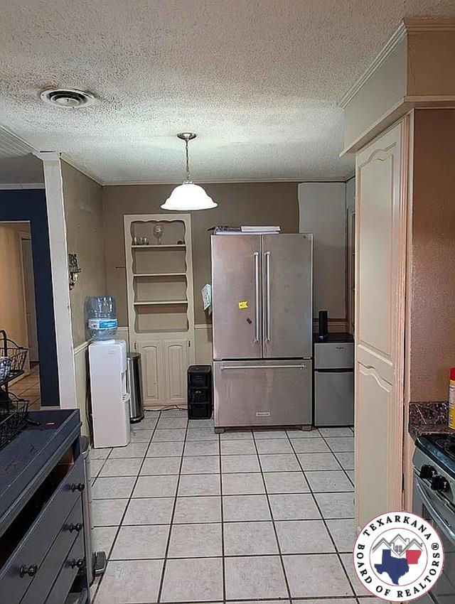 5 Sidney Dr, Texarkana, TX 75503 - kitchen featuring high end refrigerator, a textured ceiling, light tile patterned floors, black gas range oven, and dark countertops