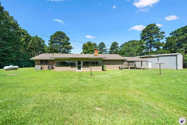 6514 Buchanan Loop, Texarkana, TX 75501 - rear view of house featuring a detached carport, a yard, brick siding, and an outbuilding