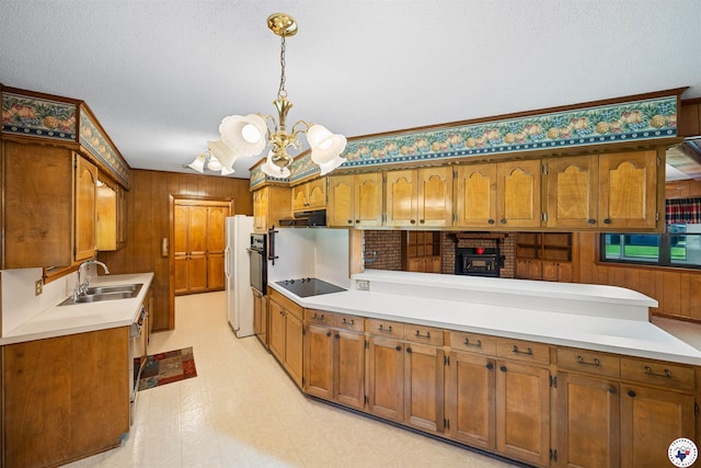 6514 Buchanan Loop, Texarkana, TX 75501 - kitchen featuring black electric stovetop, a chandelier, exhaust hood, brown cabinetry, and wood walls