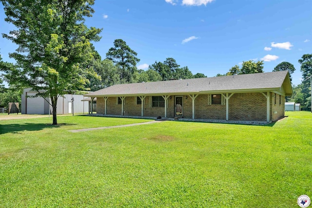 6514 Buchanan Loop, Texarkana, TX 75501 - view of front of home with a front yard, an outbuilding, a detached garage, and brick siding