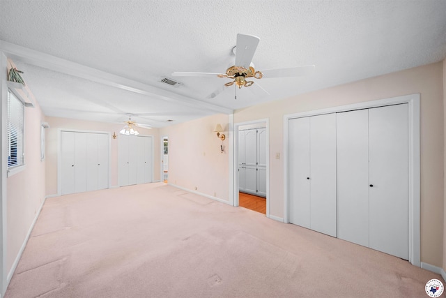 6514 Buchanan Loop, Texarkana, TX 75501 - unfurnished bedroom with carpet, two closets, a textured ceiling, and a ceiling fan