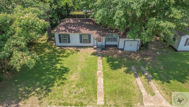 view of front of property featuring a front yard and a storage shed