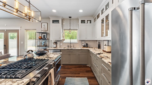 6917 Woodmere Ct, Texarkana, TX 75503 - kitchen with stainless steel appliances, dark wood-style flooring, light stone countertops, pendant lighting, and tasteful backsplash