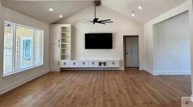 unfurnished living room with light wood-type flooring, visible vents, beamed ceiling, and baseboards