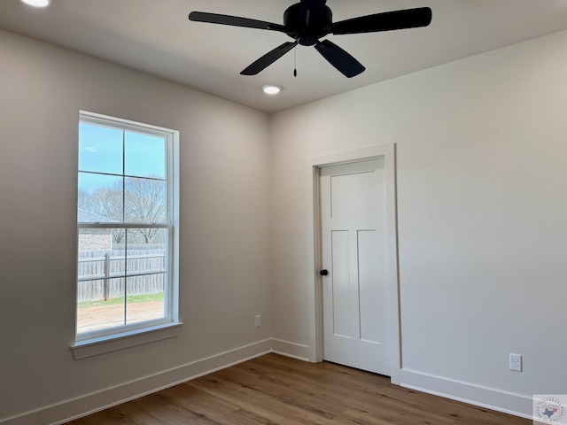 spare room featuring ceiling fan, recessed lighting, wood finished floors, and baseboards