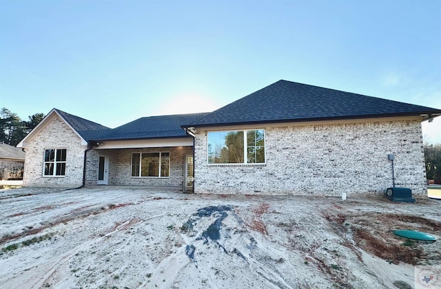 back of house with a shingled roof