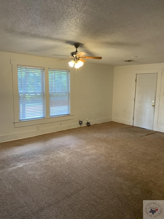 carpeted empty room featuring ceiling fan and a textured ceiling