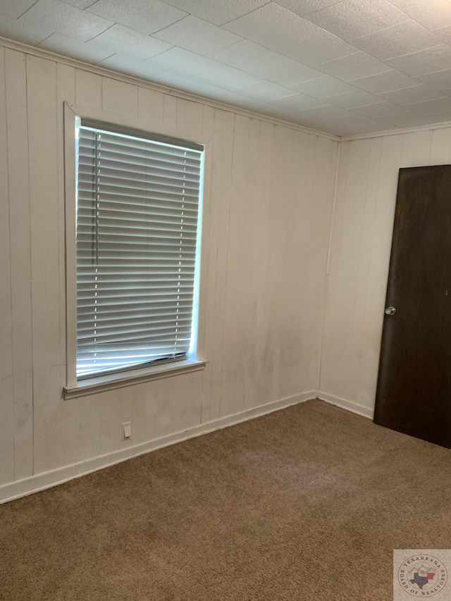 spare room with dark carpet