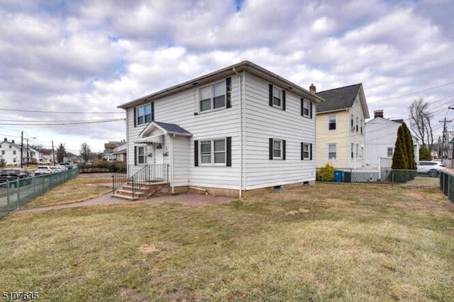 rear view of property with a yard and central air condition unit