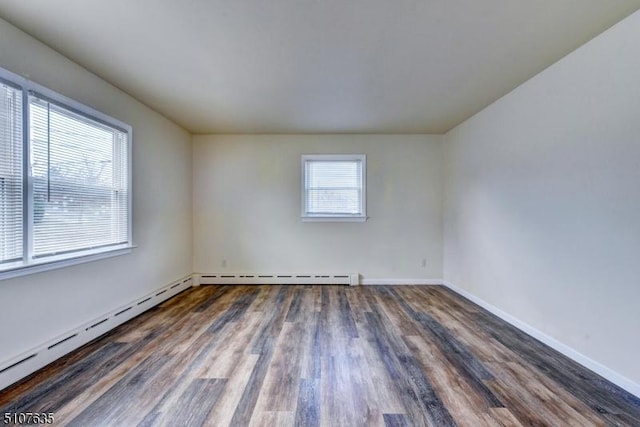 empty room with baseboard heating and dark wood-type flooring