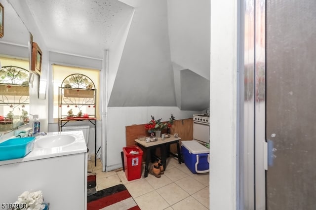 bathroom featuring lofted ceiling, vanity, and tile flooring